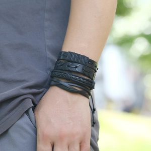 Close-up of black multilayer braided leather bracelets on a male wrist in nature