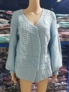 Close-up of light blue chunky knit mohair cardigan with detailed cable stitch texture
