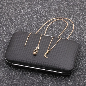 Detailed shot of gold moon pendant with zircon inlay on a textured black display box