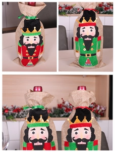 Detail of red and green linen nutcracker wine bottle covers for Christmas table decor