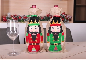 Detail of red and green burlap Christmas wine bottle covers with nutcracker soldiers