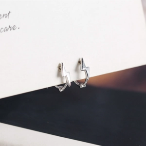 Macro di orecchini a cerchio con fulmine in argento sterling S925 su carta da esposizione