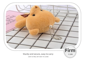 Detailed macro view of a brown plush teddy bear keychain with soft fur and a metal chain