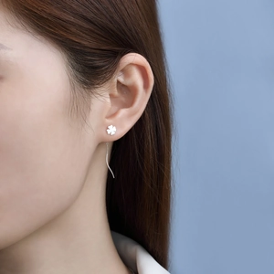 Detail view of silver S925 four-leaf clover drop earrings with curved line fringe