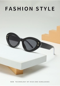 Détail de lunettes de soleil œil-de-chat noires avec branches larges et étoiles dorées