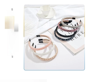 Detail of luxury hand-beaded crystal headbands in multiple colors on a soft fabric backdrop