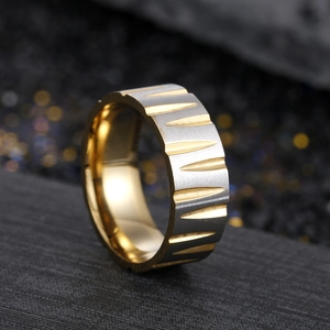 Detailed macro shot of a two-tone brushed stainless steel ring with industrial V-grooves