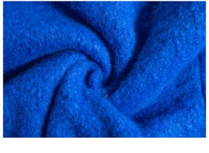 Macro detail of thick royal blue mohair fabric showing soft brushed wool texture and fringe