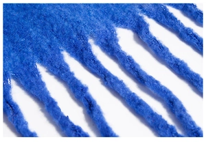 Detail of royal blue mohair knit shawl featuring thick tassel fringe and soft texture