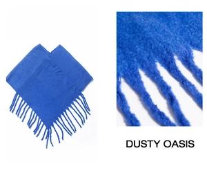 Detail of bright blue mohair knit scarf with long decorative fringe and soft texture