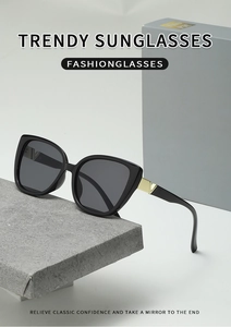 Detail view of square sunglasses featuring a golden V-shaped metal accent on the temple