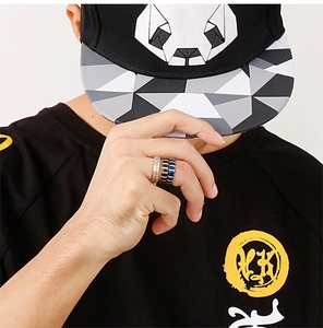 Street style shot of a man wearing a set of three stainless steel punk rings in silver black and blue