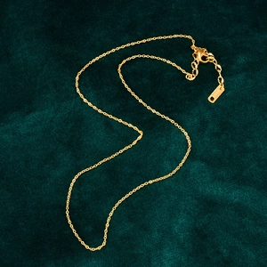 Polished 18K rose gold stainless steel cross necklace on dark green velvet background