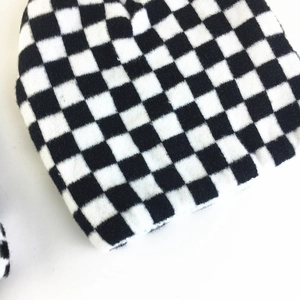 Close-up of black and white checkerboard knit texture on a cozy winter beanie