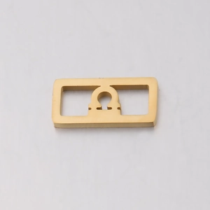 Macro shot of a golden stainless steel square pendant with Libra zodiac cutout