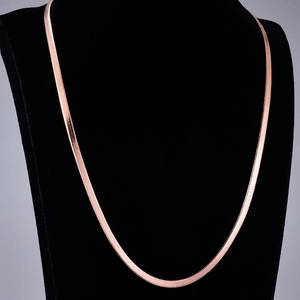 Detailed view of flat rose gold snake chain necklace on black velvet jewelry bust