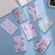 Detailed flat lay of mini flamingo pocket notebooks with cute tropical cartoon cover designs