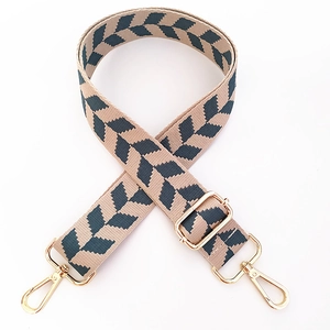 Detail view of adjustable woven strap with navy blue arrow patterns and gold hardware