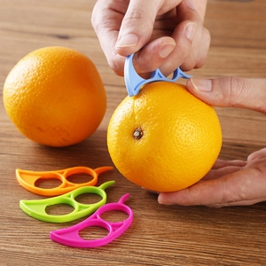 Set of four colorful citrus peelers in blue orange green and pink on a wooden table