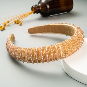 Detailed shot of handmade baroque headband with champagne crystal beads on a velvet base
