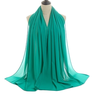 Detail of teal chiffon hijab scarf fabric texture and neat hem stitching on mannequin