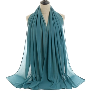 Detailed view of dark green chiffon hijab with elegant soft drapes on a mannequin