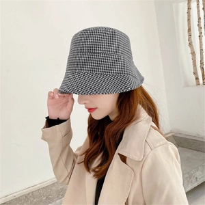 Side view of a checkered denim bucket hat with black and white houndstooth pattern