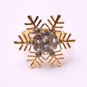 Macro detail of golden snowflake napkin ring with clear crystal rhinestones on flat surface