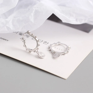 Vue macro de boucles d'oreilles créoles en argent S925 avec pendentif soleil et perles