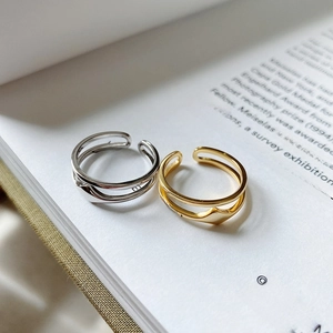 Minimalist double-layered open rings in gold and silver finish on a book page