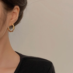 Minimalist geometric twisted gold hoop earrings for women with elegant metal finish