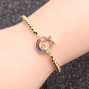 Men's gold bead bracelet featuring a colorful crystal crown charm worn on a wrist