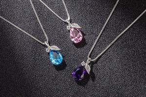 Macro detail of leaf-shaped water drop pendants in pink, light blue, and deep purple