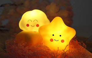 Close-up of cute smiling star and cloud LED night lights with warm yellow glow
