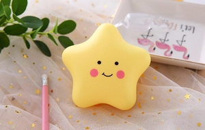 Detail of yellow star night light with cute face on flamingo tray with starry mesh backdrop