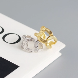 Macro shot of gold and silver chain link rings with hammer texture on a book