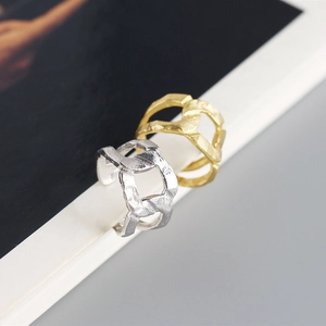 Macro view of gold and silver S925 sterling silver rings with irregular chain texture