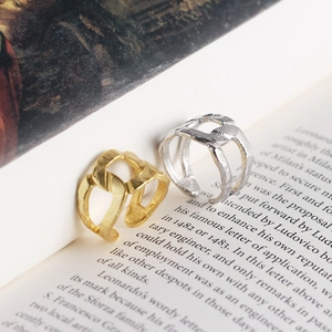 Macro shot of gold and silver S925 rings with foil texture on an open vintage book