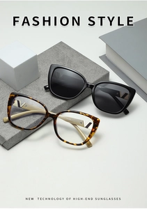 Detail view of stylish square sunglasses with golden V hardware on a geometric display