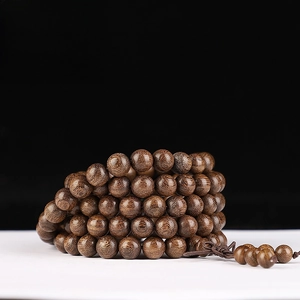 Macro detail of 8mm golden sandalwood Buddhist beads with fine grain and silk luster