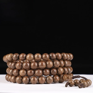 Detailed view of 10mm golden silk sandalwood 108 beads with refined wood texture