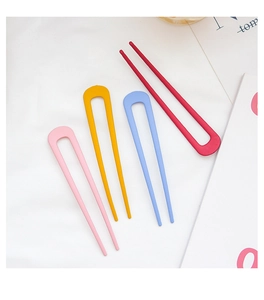 Set of four colorful matte U-shaped hair pins in pink, yellow, blue, and red tones