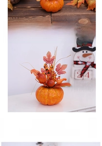 Close-up of decorative Halloween foam pumpkin with maple leaves and autumn berries