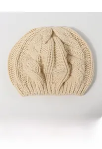 Close-up of thick beige cable knit texture and soft yarn detail on the winter beret