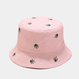 Detailed close-up of green leaf embroidery on a pink canvas reversible bucket hat