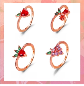 Macro display of four fruit rings: Apple, Cherry, Strawberry, and Grape designs