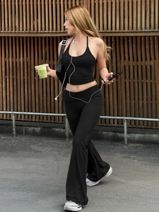 Women's black halter crop top and high waist flared leggings set for yoga and fitness