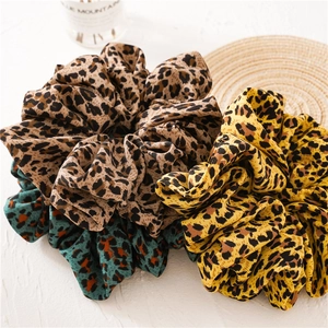 Close-up of leopard print oversized hair scrunchies in brown, yellow and green fabrics