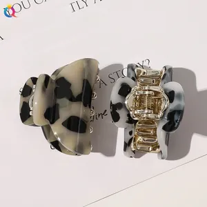 Detail of two-piece tortoiseshell hair claws with marble patterns and metal springs