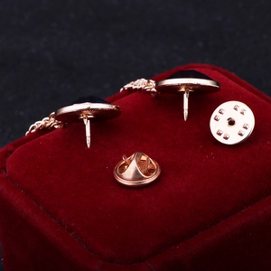 Rose gold collar pins with black gemstones and chains in a red velvet jewelry box